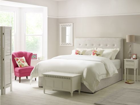 The Ellis bed, shown in an white-grey linen fabric and hand-sewn line of buttons across the headboard.