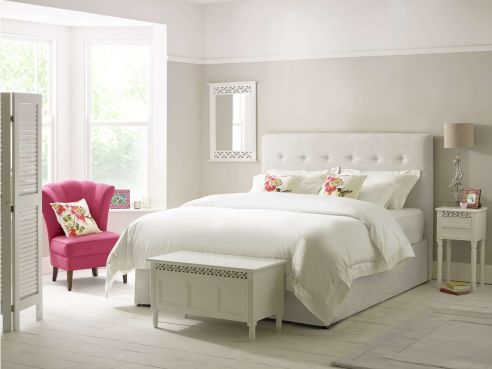 The Ellis Modern Storage Bed shown in a grey-white linen, featuring a headboard with a single line of hand-sewn buttons.