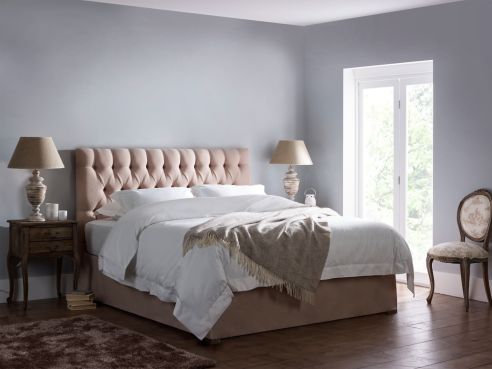 The Oscar storage bed, shown with a light pink fabric and deep buttoned headboard.